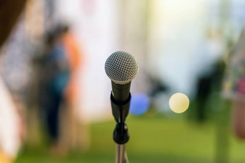 Microphone on the stage over the Abstract blurred photo of green grass
