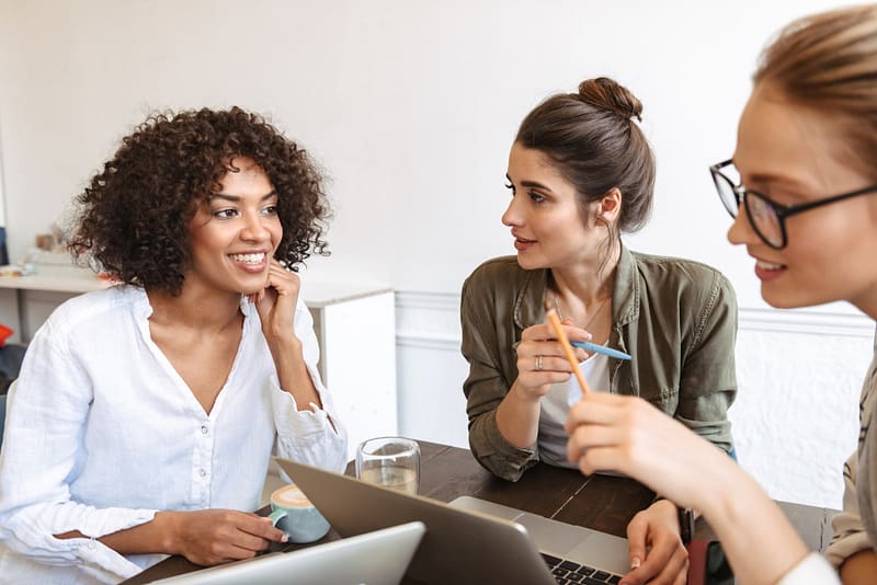 Group of cheerful young women studying together