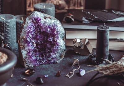 Amethyst Druze on a witch's altar for a magical ritual among crystals and black candles.